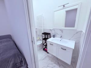 a white bathroom with a sink and a mirror at Villa Life in San Donato Milanese