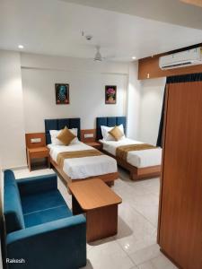 瓦皮Hotel Royal Park的酒店客房,设有两张床和一张蓝色的沙发