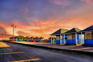 a row of houses with a sunset in the background at 6 Berth pet friendly Chalet in Mablethorpe