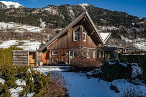 a house in the snow with mountains in the background at Chalet Sendlhofer in Bad Hofgastein