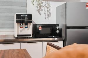 a coffee machine sitting on a counter in a kitchen at Taiping Rain Suite Homestay near Lake Garden with Netflix WiFi in Taiping +28 photos