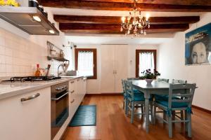 eine Küche mit einem Tisch und Stühlen sowie ein Esszimmer in der Unterkunft Ca' Giardini in Venedig