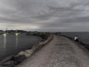 a group of people standing on a rock wall by the water at Quarto com suite em casa familiar , pé na areia na praia do Perequê em Porto Belo SC , somente o quarto e o banheiro privativo as demais dependências não estão inclusas in Porto Belo