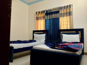 two beds sitting next to each other in a room at The TravelLodge Inn in Islamabad
