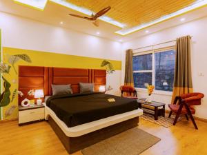 a bedroom with a large bed and a ceiling fan at The Hosteller Lansdowne in Lansdowne