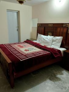 una camera da letto con un letto grande con testiera in legno di The TravelLodge Inn a Islamabad