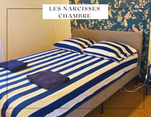 a bed with blue and white striped pillows on it at Porte des remparts in Ensisheim