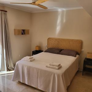 a bedroom with a bed with two towels on it at Apartamento duplex en resort de golf y playa in Atamaría