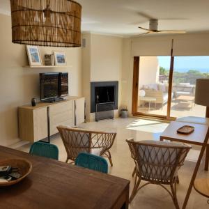 a living room with a table and chairs and a fireplace at Apartamento duplex en resort de golf y playa in Atamaría