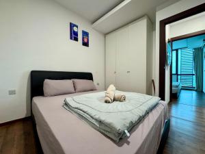 a bedroom with a bed with a stuffed animal on it at Vivacity Cozy Jazz4 2R1B wNetflix, 7pax YPM1202 in Kuching