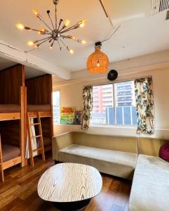 a living room with a couch and a table and a window at Riverside HOSTEL CHILLAX Namba in Osaka