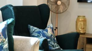 Una sala de estar con una silla azul con almohadas. en Apartment Seven, en Shrewsbury