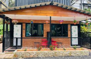 a brick building with red chairs and tables at Big Dreams Hotel in Tanah Rata