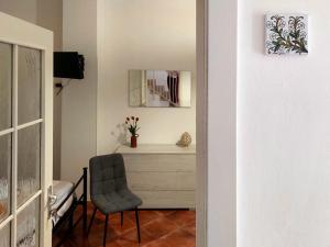 a room with a chair and a dresser with a mirror at Cocciu d'Amuri Netino in Noto