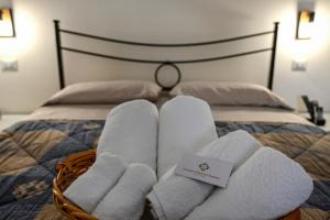 a basket of towels on top of a bed at Cocciu d'Amuri Netino in Noto