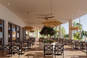 a restaurant with tables and chairs and umbrellas at PortoBay Blue Ocean in Albufeira