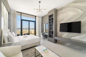 um quarto de hotel com uma cama e uma TV de tela plana em Charming new studio with pool and gym in Al Furjan no Dubai