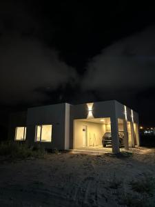 un edificio con un coche aparcado delante de él por la noche en Casa barrio Las Lomas 2, en Monte Hermoso
