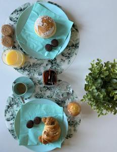two plates of pastries and a cup of coffee and a plate of desserts at Villa Enza B&B in Ginosa