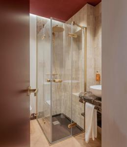 a bathroom with a glass shower with a sink at LIRIUM Casa Patio in Seville