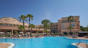a pool at a resort with people sitting in chairs and umbrellas at PortoBay Blue Ocean in Albufeira