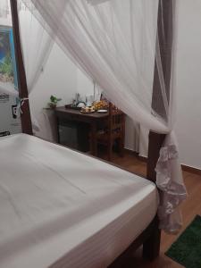a bedroom with a table and a bed with curtains at Sunset view cabana in Tangalle