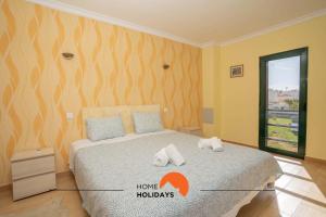 a bedroom with a bed with towels on it at #039 Family Private Pool AC in Vale de Pedras