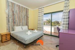 a bedroom with a bed and a large window at #039 Family Private Pool AC in Vale de Pedras