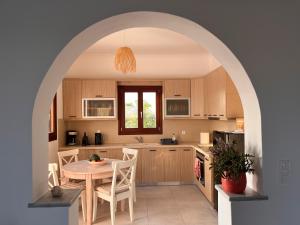 a kitchen with an archway with a table and chairs at Beach front Villa Pasithea in Monolithos