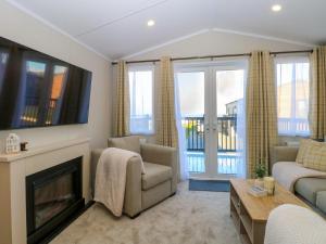 a living room with a fireplace and a tv at The Sea Lodge in Norwich