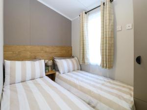two beds in a small room with a window at The Sea Lodge in Norwich +17 photos