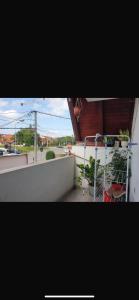 a balcony with a bed and plants on a building at Apartman- Ledine in Ledine +8 photos