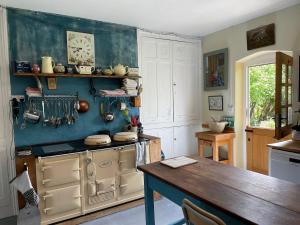 a kitchen with a stove and a wooden table at Lower Buckton Country Living Big House near Ludlow 6 bedrooms sleep 12 in Leintwardine