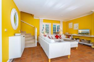 ein Wohnzimmer mit gelben Wänden und weißen Möbeln in der Unterkunft Friesenhaus Horsum Huis Friesenhaus Morsum Huis in Morsum + 24 Fotos