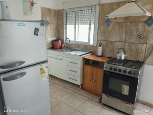 a kitchen with a white refrigerator and a stove at DEPTOS VM Complejo x 3 in Villa María
