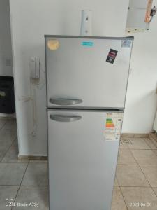 a white refrigerator in a kitchen with a phone at DEPTOS VM Complejo x 3 in Villa María