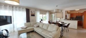 a living room with a white couch and a kitchen at Latchi Aria villa in Neo Chorio