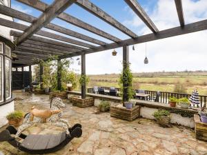 an outdoor patio with a wooden pergola at Riverside Manor in Offenham