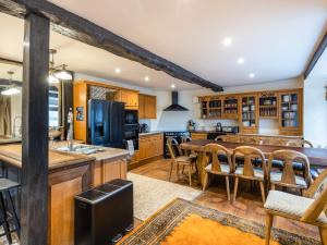 a kitchen with wooden cabinets and a table and chairs at Riverside Manor in Offenham