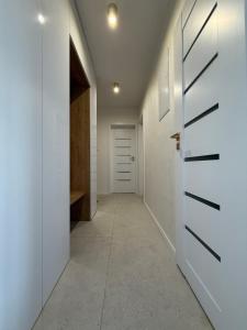 a hallway with white walls and a door at Mountain Heim Apartment in Poprad