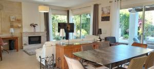 a living room with a table and a fireplace at Latchi Aria villa in Neo Chorio