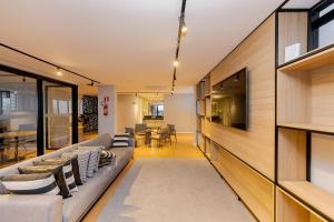 an open living room with a couch and a dining room at Elysia in Curitiba