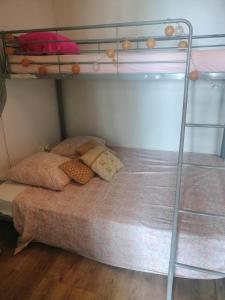 a bunk bed with two pillows and a ladder at KAZANNa in Sainte-Clotilde