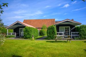 a house with a picnic table in the yard at Lodges De Driesprong Domburg in Domburg