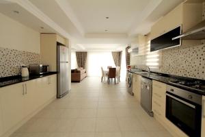 a large kitchen with appliances and a living room at Villa Oludeniz Heights in Fethiye