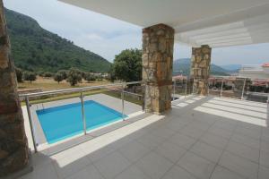 a balcony of a house with a swimming pool at Villa Oludeniz Heights in Fethiye