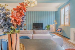ein Wohnzimmer mit einer Couch und einem Tisch mit Blumen in der Unterkunft Dolcevita PentHouse - A due passi dalla Ghirlandina in Modena