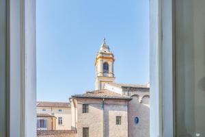 ein Blick aus dem Fenster eines Gebäudes mit einem Glockenturm in der Unterkunft Dolcevita PentHouse - A due passi dalla Ghirlandina in Modena