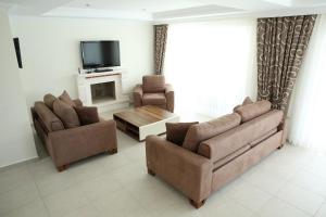 a living room with two couches and a tv at Villa Oludeniz Heights in Fethiye