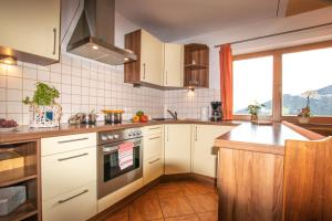 kuchnia z białymi szafkami i kuchenką w obiekcie Ferienwohnung bis 4 Personen in Traumlage mit Kaiserblick by FeWo-Plan WILD190 w mieście Thierbach